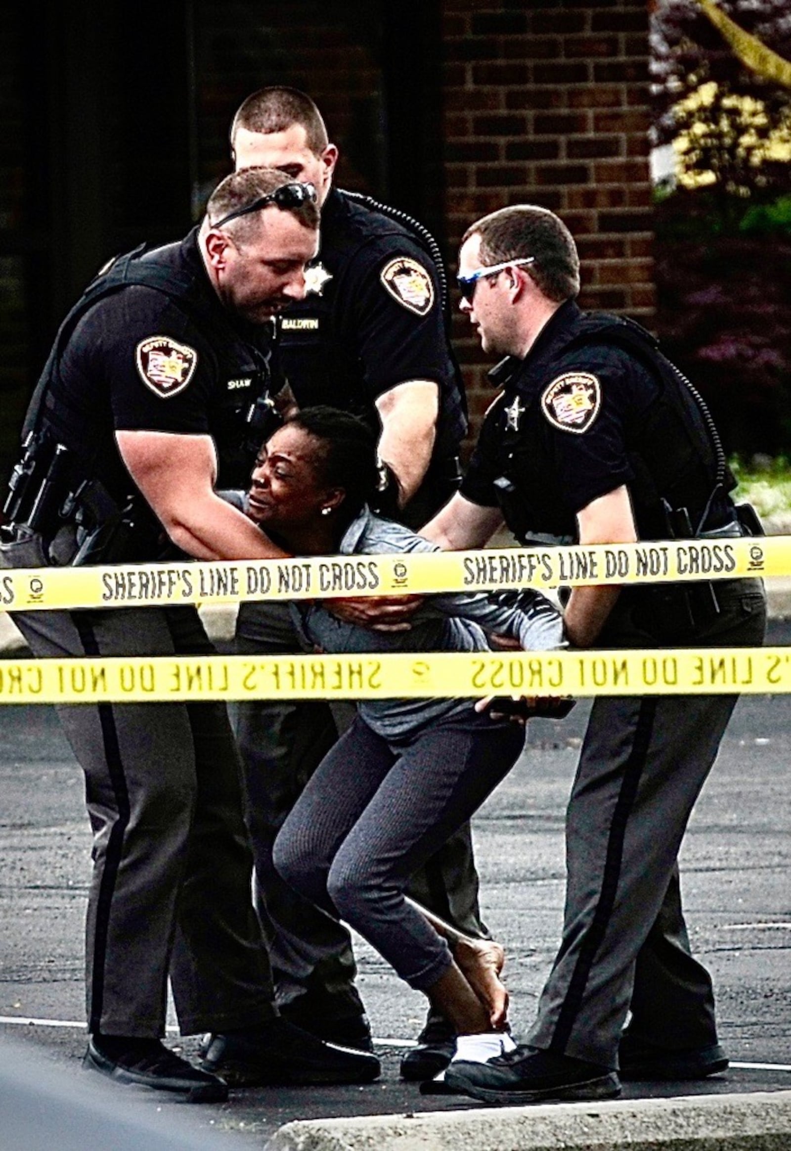 Police surround a distraught woman at the scene of a crash and possible shooting on South Limestone Street Wednesday, May 14, 2025. MARSHALL GORBY/CONTRIBUTED