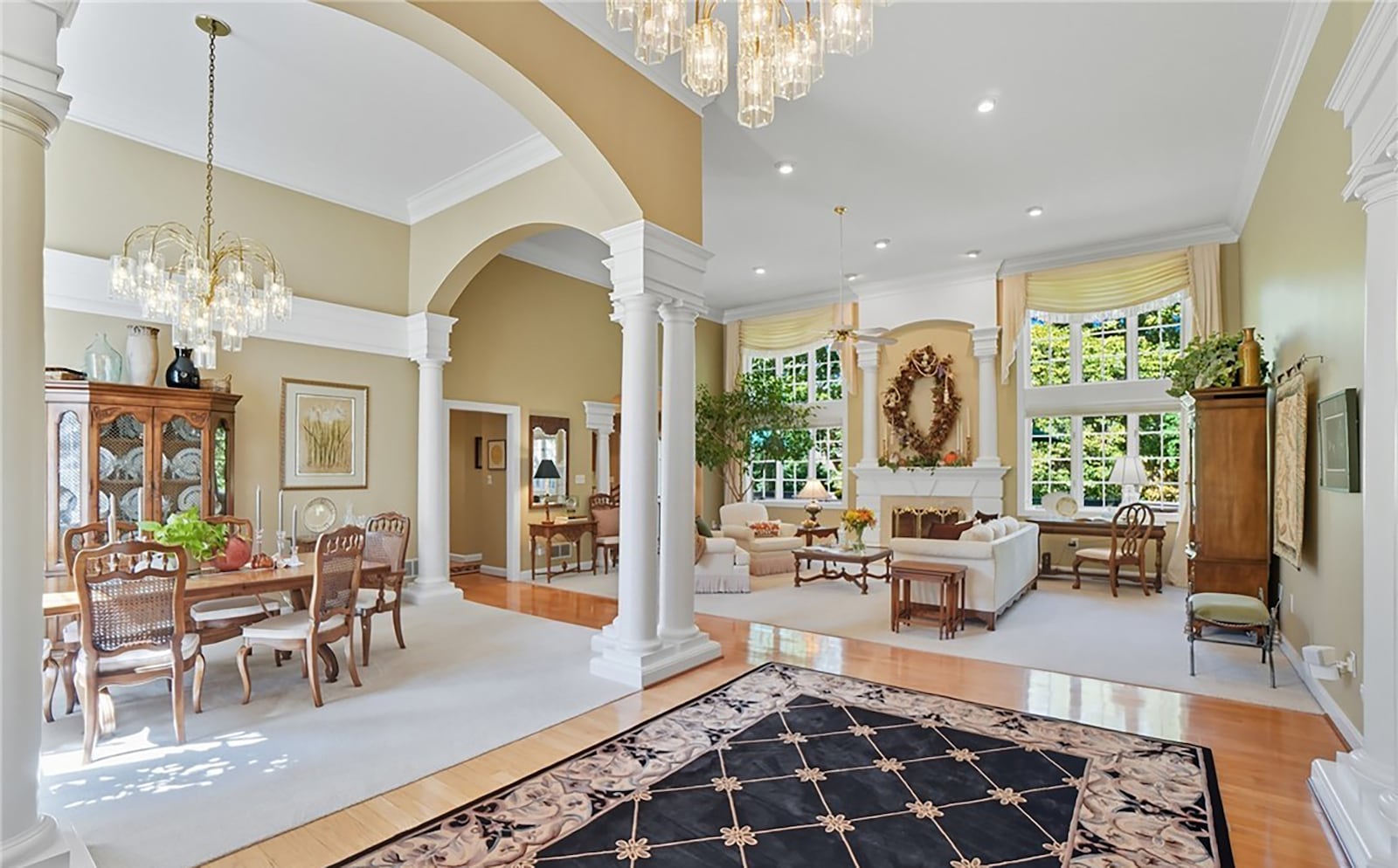 The open concept dining and great rooms both have vaulted ceilings and neutral carpeting. The great room has a fireplace and recessed lighting and the dining room has a crown molding and a chandelier. CONTRIBUTED