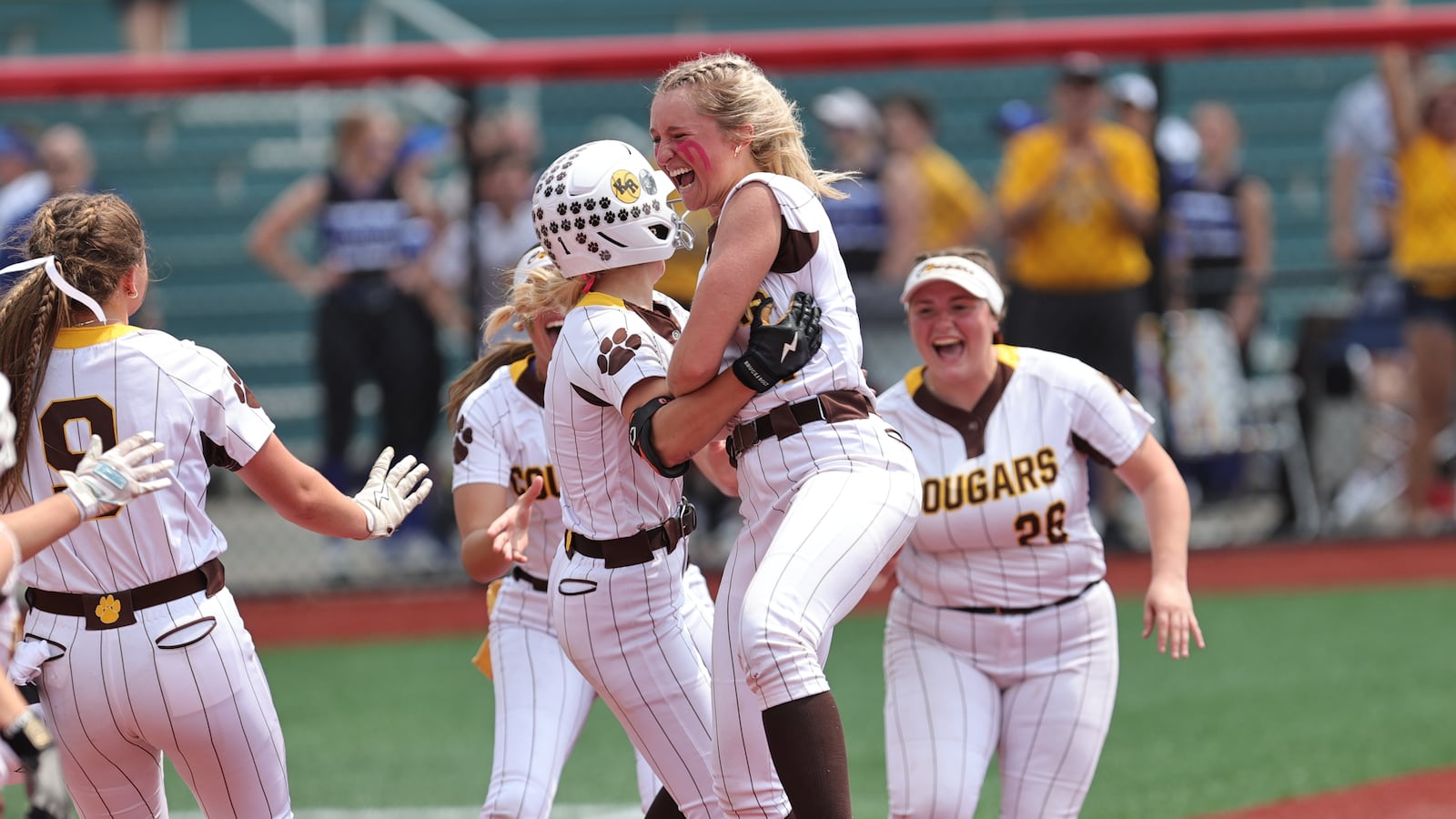 Kenton Ridge High School sophomore Jayden Davis hugs sophomore Chloe Glass after she scored the winning run to beat Lexington 4-3 in a Division IV state semifinal game on Wednesday afternoon at Akron Firestone Stadium. MICHAEL COOPER / STAFF PHOTO