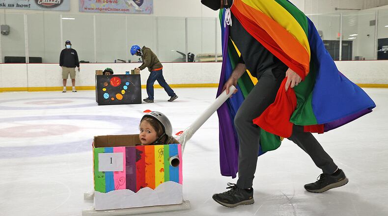Jack Driscoll, 2, looks a little nervous as her father, Jeff, pushes her in a brightly colored cardboard bobsled Saturday during one of the races at The Chiller Ice Rink. BILL LACKEY/STAFF