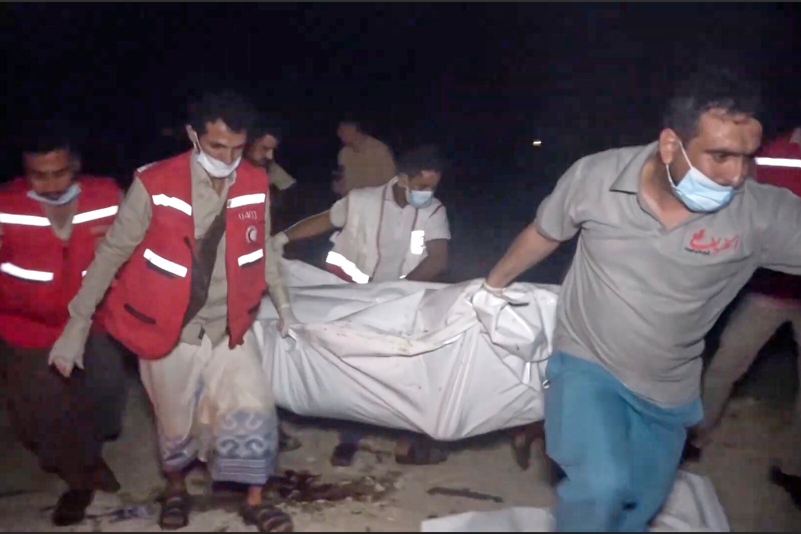 This photo taken from video released by Al Masirah TV channel shows medics carrying a dead person after U.S. airstrikes targeted the Ras Isa oil port held by Yemen's Houthi rebels in Hodeida, Yemen, Friday, April 18, 2025.( Al Masirah TV via AP)