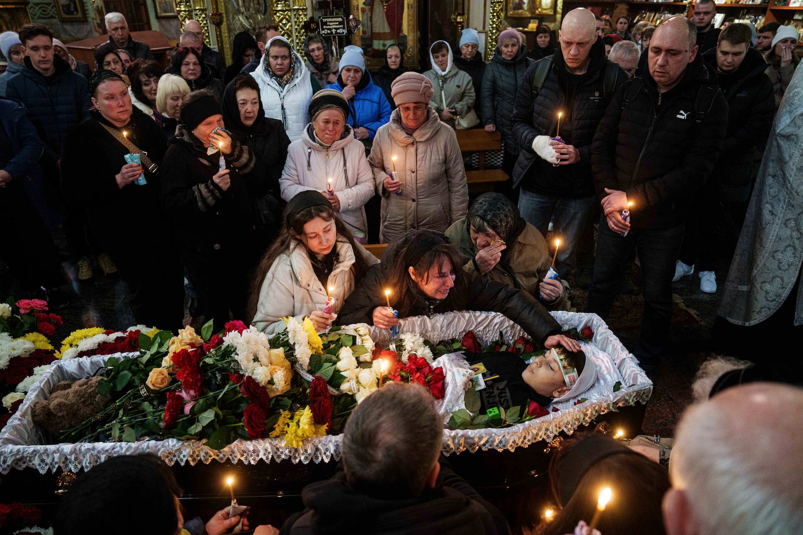 FILE- A mother cries over the coffin of her son Herman Tripolets, 9, killed by a Russian missile, during a funeral ceremony in Kryvyi Rih, Ukraine, April 7, 2025. (AP Photo/Evgeniy Maloletka, File)
