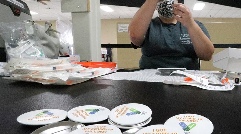 Cheyenne Bumgarner, from the Clark County Combined Health District, load a syringe with COVID vaccine last week at the new vaccine center on Leffel Lane. BILL LACKEY/STAFF