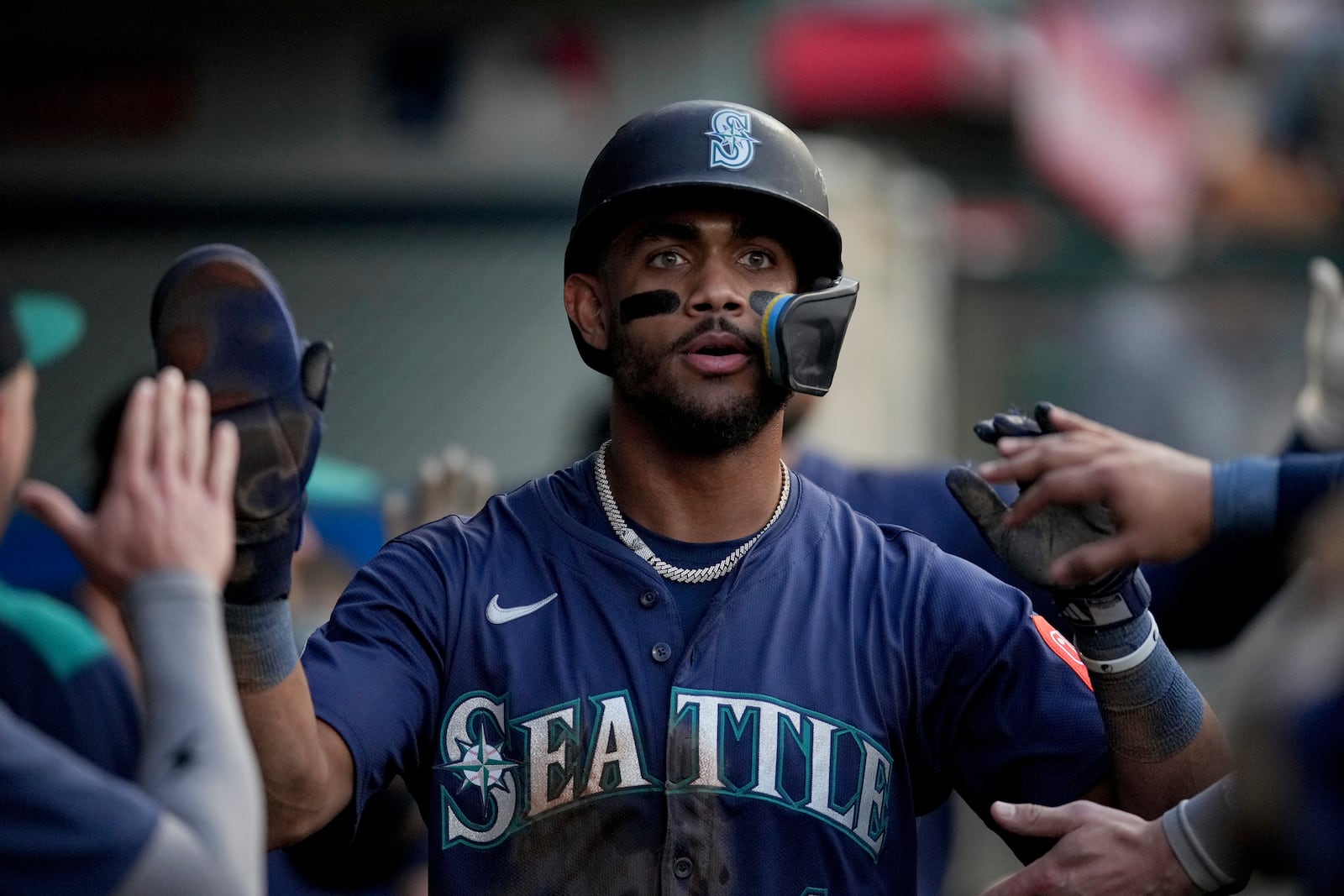 Seattle Mariners' Julio Rodriguez celebrates with teammates in the dugout after scoring a run during the fourth inning of a baseball game against the Los Angeles Angels Friday, June 6, 2025, in Anaheim, Calif. (AP Photo/Eric Thayer)