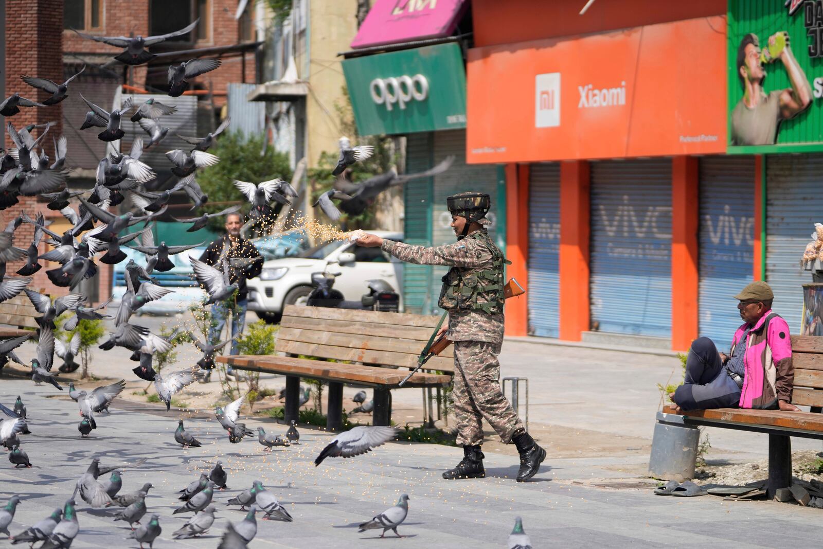 An Indian soldier feeds pigeons at a market, day after India and Pakistan agreed to a ceasefire Saturday following U.S.-led talks to end the most serious military confrontation between the nuclear-armed rivals in decades, in Srinagar, in Indian controlled Kashmir, Sunday, May 11, 2025.(AP Photo/Mukhtar Khan)