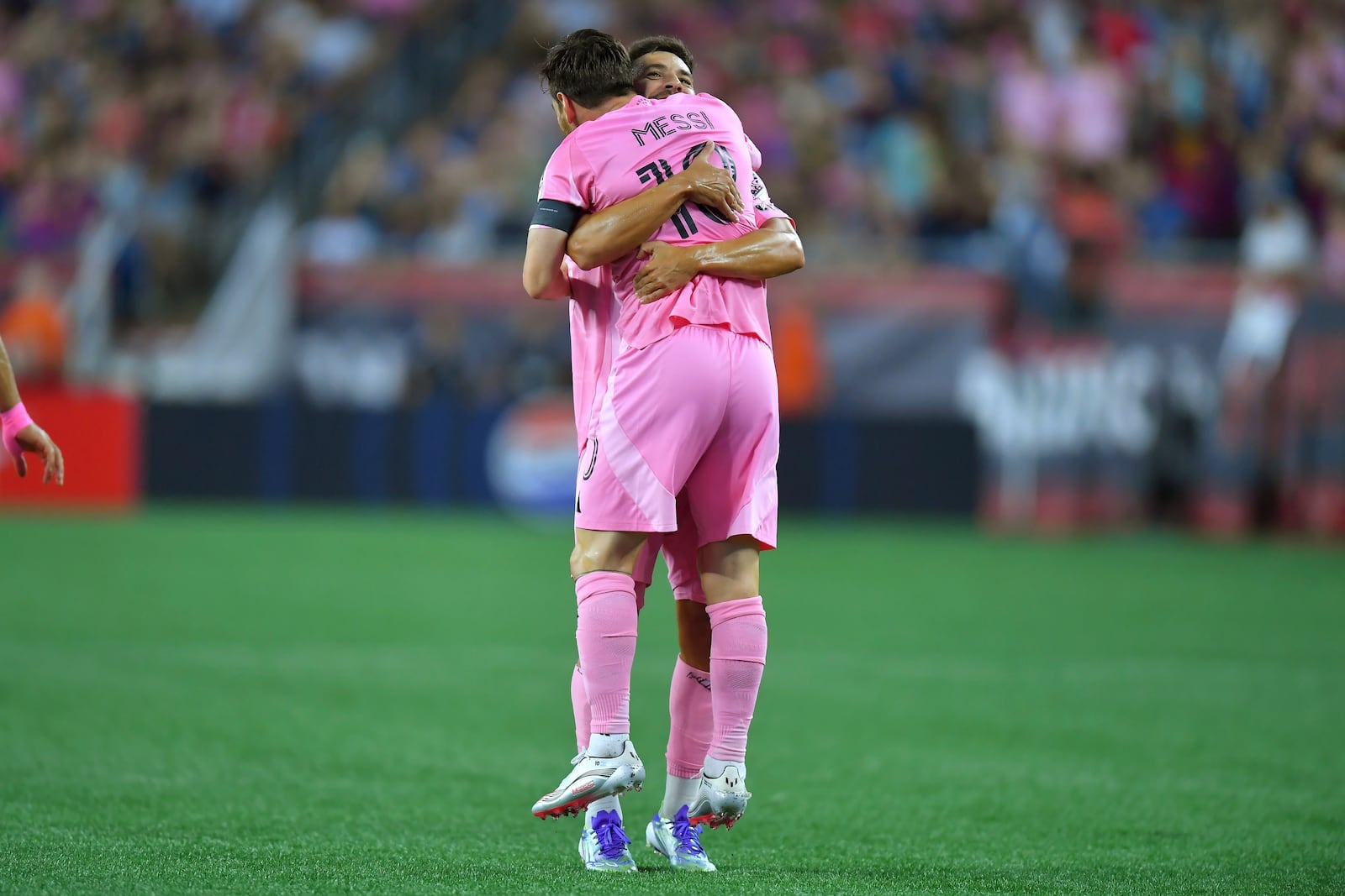 Inter Miami defender Jordi Alba, behind, lifts forward Lionel Messi (10) as they celebrate Messi's goal in the first half of an MLS soccer match against the New England Revolution, Wednesday, July 9, 2025, in Foxborough, Mass. (AP Photo/Steven Senne)