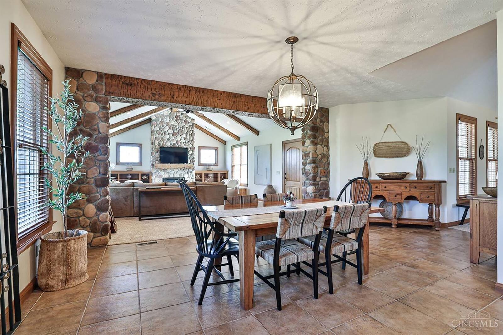 The eat in kitchen is open to the family room addition. It has wood beams, a vaulted ceiling and floor to ceiling river rock fireplace.