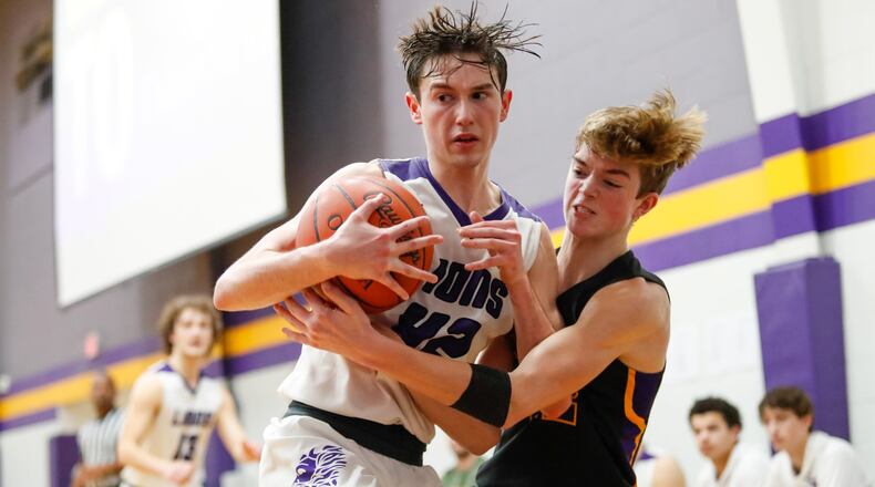 Emmanuel Christian Academy’s Noah Willis and Dayton Christian’s Devin Drier battle for the basketball during their game on Friday night in Springfield. The Lions won 49-40. CONTRIBUTED PHOTO BY MICHAEL COOPER