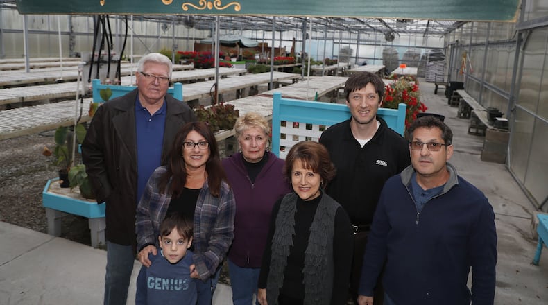 Several generations of the Capelli family pose for picture in the Capelli greenhouse on East Leffel Lane Wednesday. The Capelli family is auctioning off 197-acre piece of farm land that has been in their family for almost 100 years. Bill Lackey/Staff