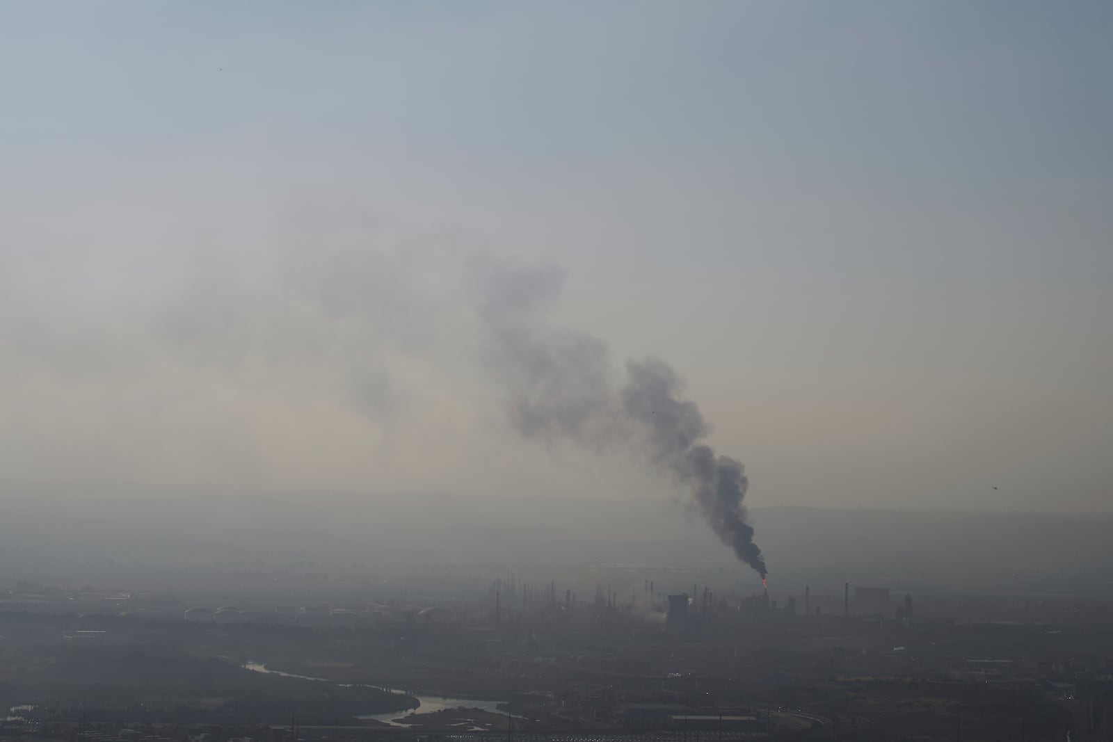 Smoke billows after an Iranian missile struck an oil refinery in Haifa, northern Israel, early Monday, June 16, 2025. (AP Photo/Ariel Schalit)