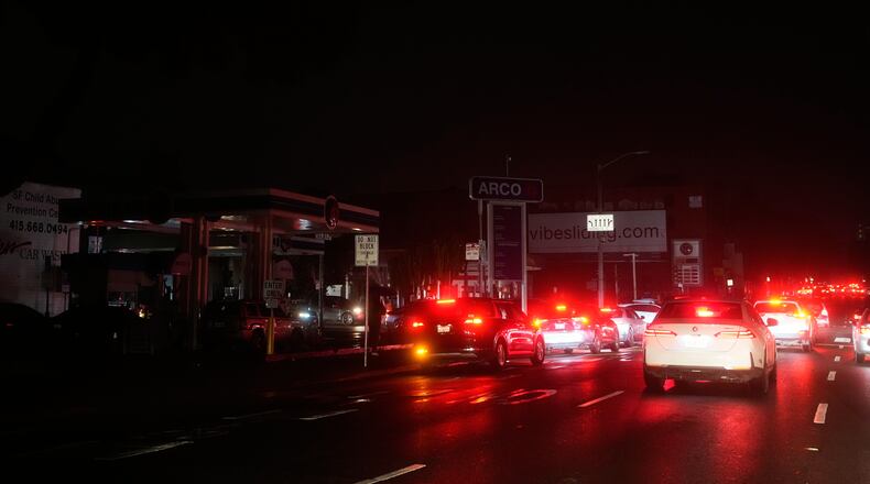 Cars wait at an intersection with no working traffic lights from power outages, in San Francisco, Saturday, Dec. 20, 2025. (AP Photo/Jeff Chiu)