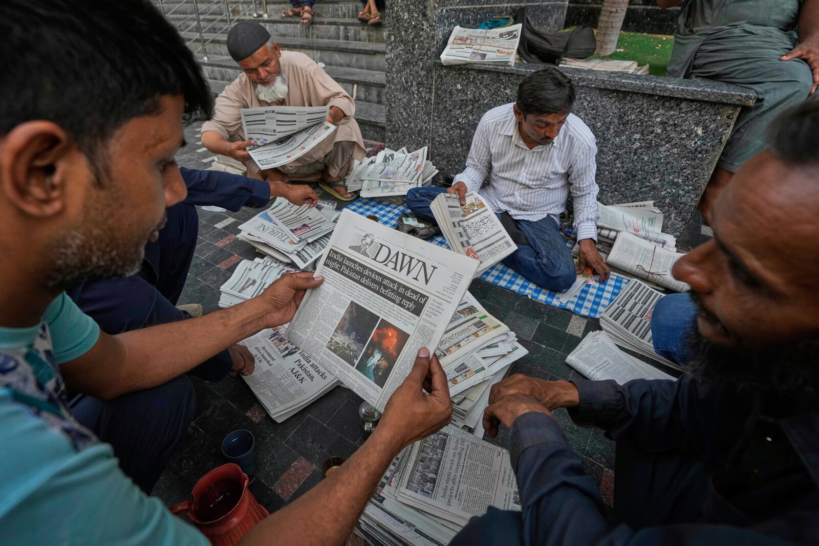 People read morning newspapers leading with the story of India firing missiles into Pakistani territory, in Karachi, Pakistan, Wednesday, May 7, 2025. (AP Photo/Fareed Khan)