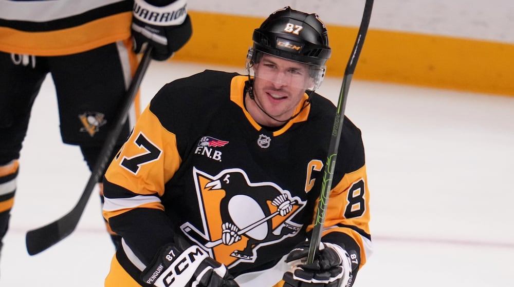 Pittsburgh Penguins' Sidney Crosby skates to his bench after scoring a goal that tied him with former Penguins player Mario Lemieux for the team's all-time points leader, during the first period of an NHL hockey game against the Montréal Canadiens in Pittsburgh, Sunday, Dec. 21, 2025. (AP Photo/Gene J. Puskar)