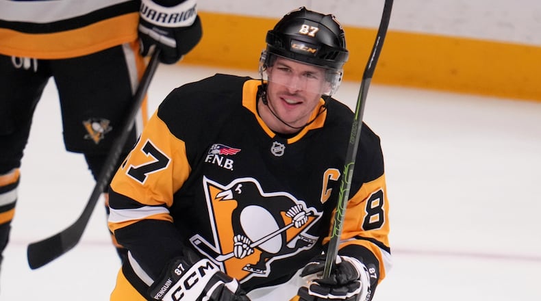 Pittsburgh Penguins' Sidney Crosby skates to his bench after scoring a goal that tied him with former Penguins player Mario Lemieux for the team's all-time points leader, during the first period of an NHL hockey game against the Montréal Canadiens in Pittsburgh, Sunday, Dec. 21, 2025. (AP Photo/Gene J. Puskar)