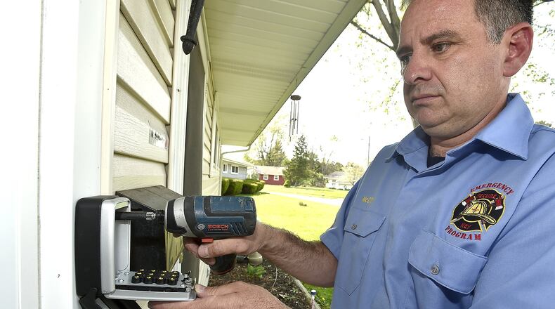 Vince McCoy, one of the owners of Secure-a-Key, installs a key box on the front of a house in Springfield. McCoy and his partner Rob Fenwick started a company where keys lockboxes are placed on elderly people’s homes in the event where medics are called to the house and can’t get in during an emergency. Bill Lackey/Staff