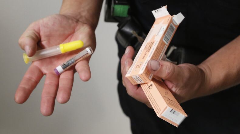 During his shift Tuesday, Dayton Police Department Officer Joe Sheen replenishes his supply of Narcan. CHRIS STEWART / STAFF