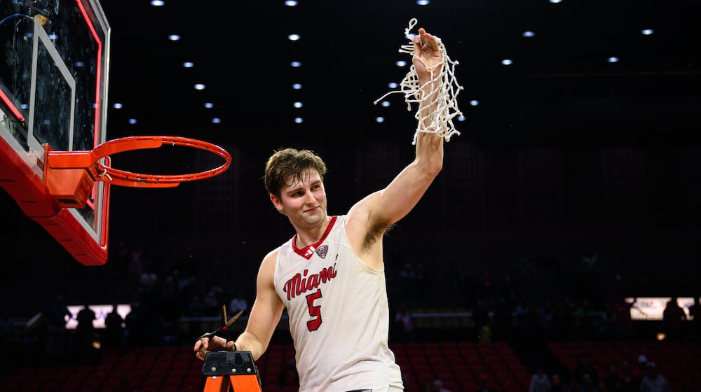 Miami University's Peter Suder raises the net towards the crowd in celebration after the RedHawks beat Toledo 74-72 in Mid-American Conference action on Tuesday, March 3, 2026 at Millett Hall. Miami clinched its first MAC regular season crown since the 2004-05 season. JEREMY MILLER / CONTRIBUTED PHOTO