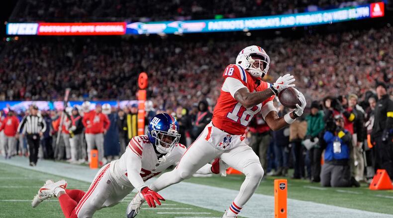New England Patriots wide receiver Kyle Williams (18) catches a touchdown pass against New York Giants cornerback Paulson Adebo (21) during the first half of an NFL football game Monday, Dec. 1, 2025, in Foxborough, Mass. (AP Photo/Charles Krupa)