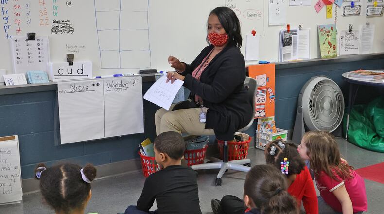 Students in Marcy'a Wilson-Jackson's first grade class at Perrin Woods Elementary practice math problems on the dry erase board in early March. BILL LACKEY/STAFF