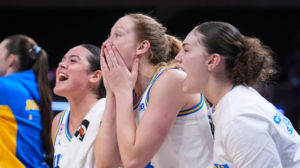 UCLA guard Charlisse Leger-Walker, left, guard Gianna Kneepkens, center, and guard Christina Karamouzi celebrate on the bench in the second half of an NCAA college basketball game in the finals of the Big Ten Conference tournament, Sunday, March 8, 2026 in Indianapolis. (AP Photo/Michael Conroy)