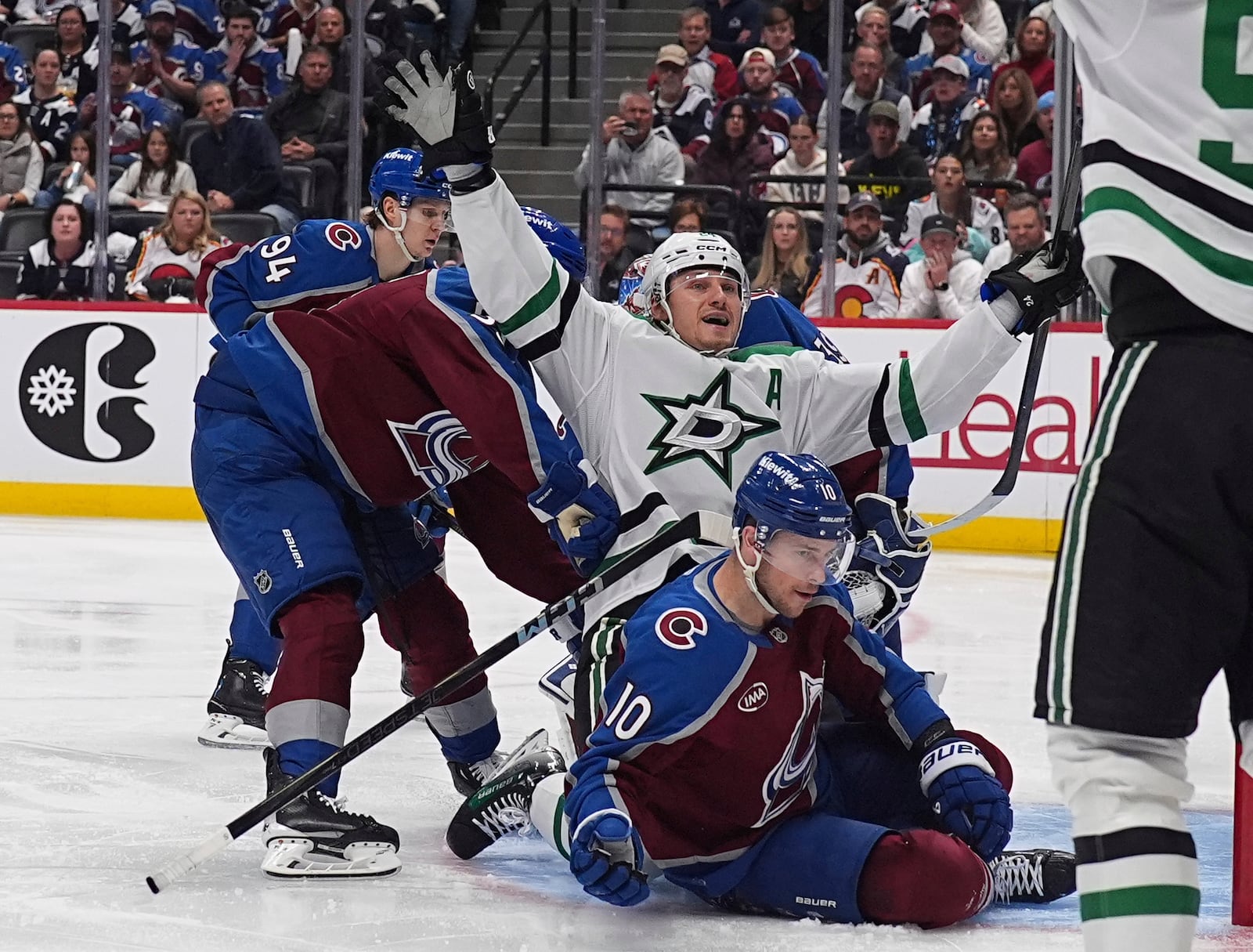 Dallas Stars center Roope Hintz, center top, celebrates after driving past Colorado Avalanche defenseman Ryan Lindgren, front left, and center Charlie Coyle (10) to score in the second period of Game 6 of an NHL hockey first-round playoff series Thursday, May 1, 2025, in Denver. (AP Photo/David Zalubowski)