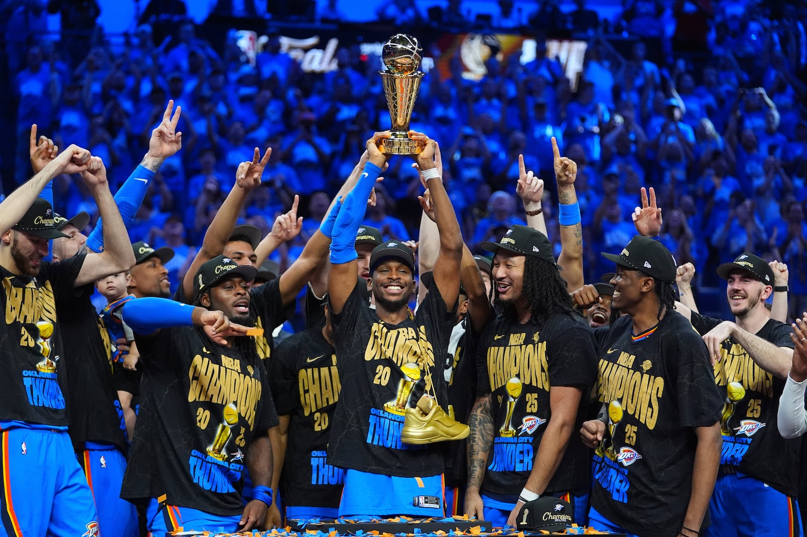 Oklahoma City Thunder guard Shai Gilgeous-Alexander, center, holds up the MVP trophy as he celebrates with his team after they won the NBA basketball championship with a Game 7 victory against the Indiana Pacers Sunday, June 22, 2025, in Oklahoma City. (AP Photo/Julio Cortez)