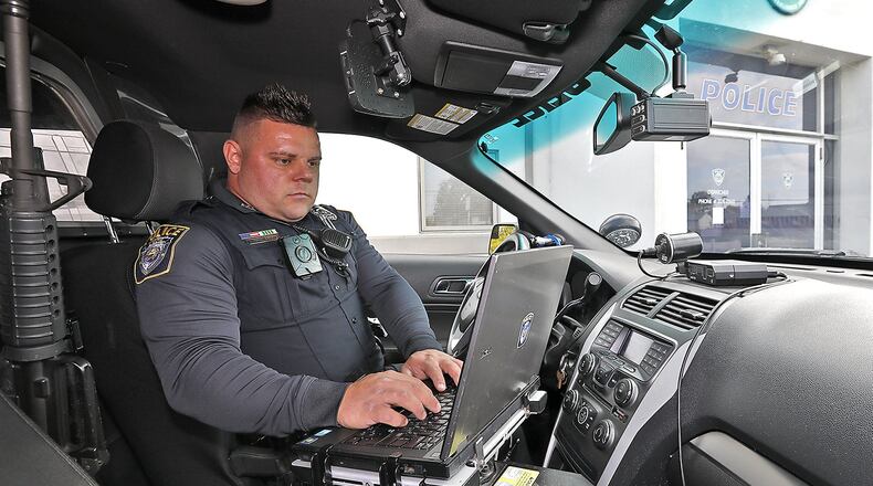 Enon Police Officer Mike Stratton prepares to start his shift Friday. Bill Lackey/Staff