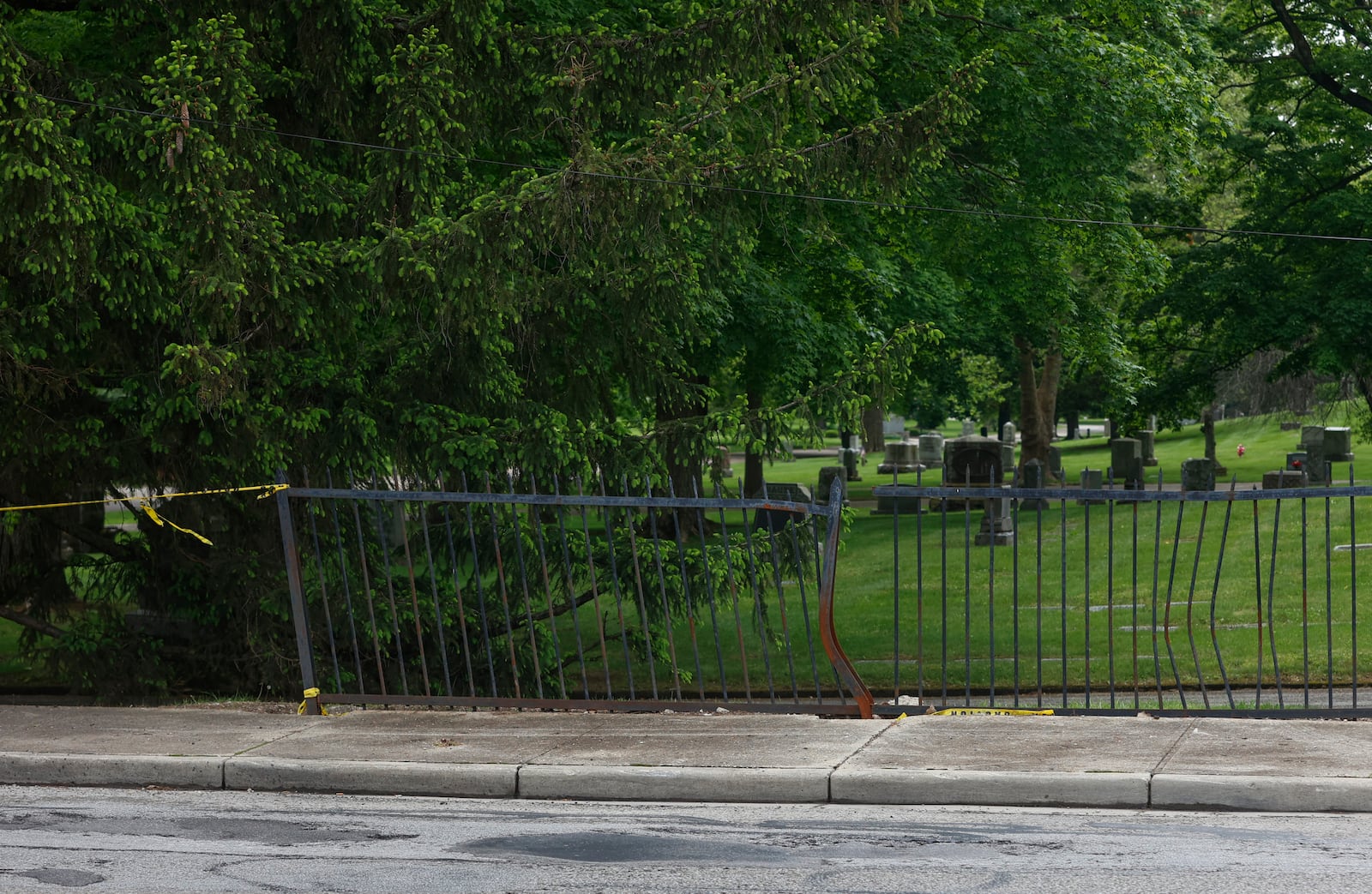 The damaged fence of Ferncliff Cemetery on Tuesday, May 13, 2025. The fence has been hit by cars 65 times since 2018 and cemetery workers have advocated for changes to stop the accidents. JOSEPH COOKE/STAFF