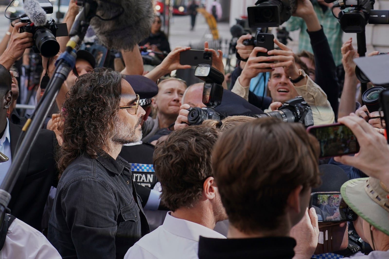Russell Brand surrounded by media as he arrives at Westminster Magistrates' court in London, Friday, May 2, 2025, where he faces, rape and sexual assault charges involving four women. (AP Photo/Alberto Pezzali)