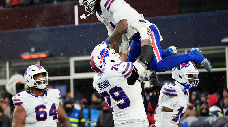 Buffalo Bills running back James Cook III, top, celebrates with offensive tackle Spencer Brown (79) after scoring against the New England Patriots during the second half of an NFL football game in Foxborough, Mass., Sunday, Dec. 14, 2025. (AP Photo/Robert F. Bukaty)