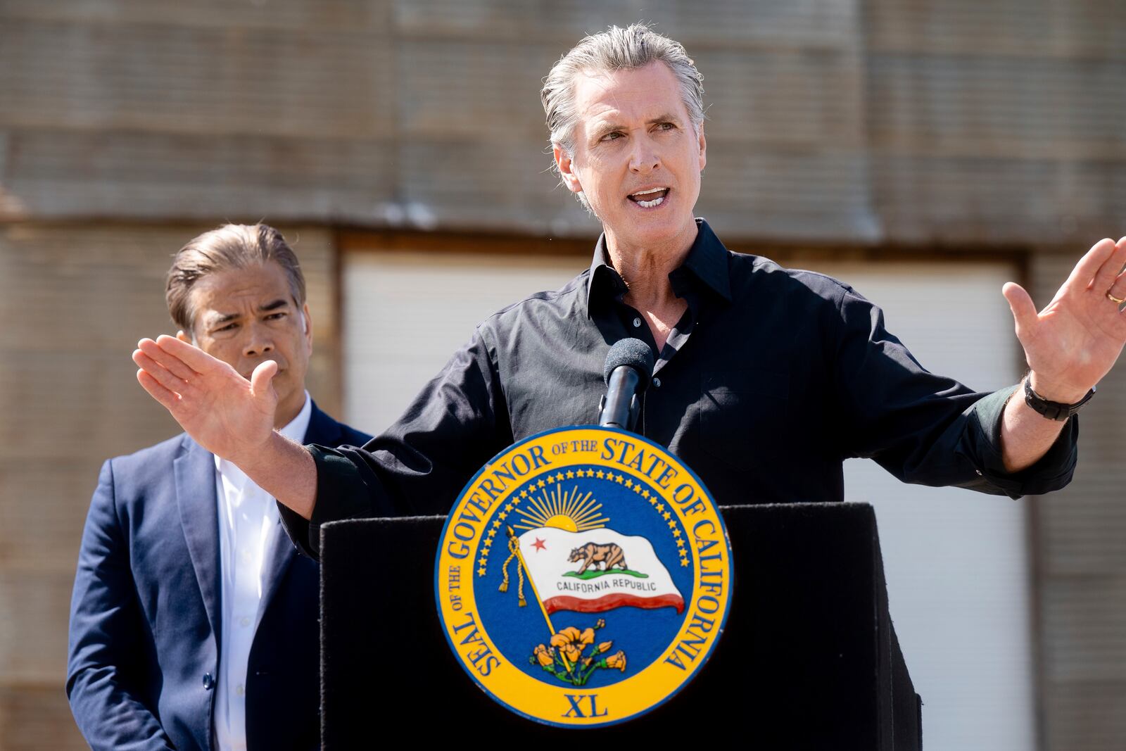 California Gov. Gavin Newsom discusses President Donald Trump's tariffs, as California Attorney General Rob Bonta, left, listens, during a press conference on Wednesday, April 16, 2025, at an almond farm in Ceres, Calif. (AP Photo/Noah Berger)