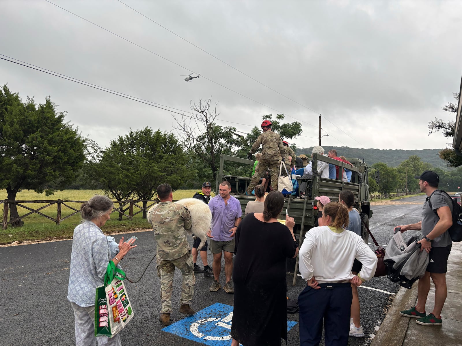 Residents prepare for transport away from Hunt, Texas, at 6:26 p.m. on Friday, July 4, 2025, after floodwaters from the Guadalupe River devastated their town. (Shabd Simon-Alexander via AP)