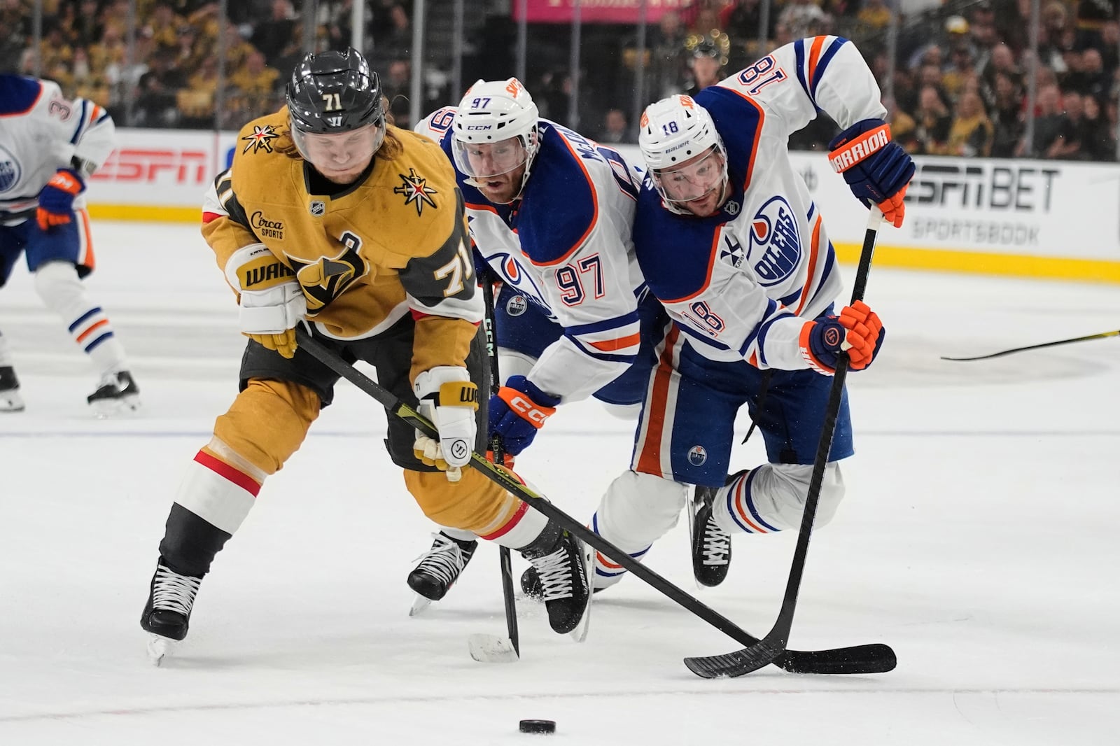 Vegas Golden Knights center William Karlsson (71), Edmonton Oilers center Connor McDavid (97) and Edmonton Oilers left wing Zach Hyman (18) vie for the puck during the first period of Game 2 of a second-round NHL hockey playoff series Thursday, May 8, 2025, in Las Vegas. (AP Photo/John Locher)