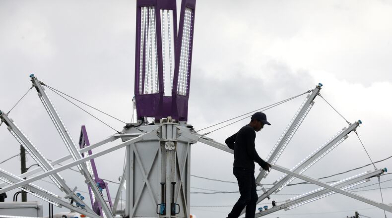 A Durant Amusements employee sets up a ride on the midway at the Clark County Fair Monday, July 19, 2022. BILL LACKEY/STAFF