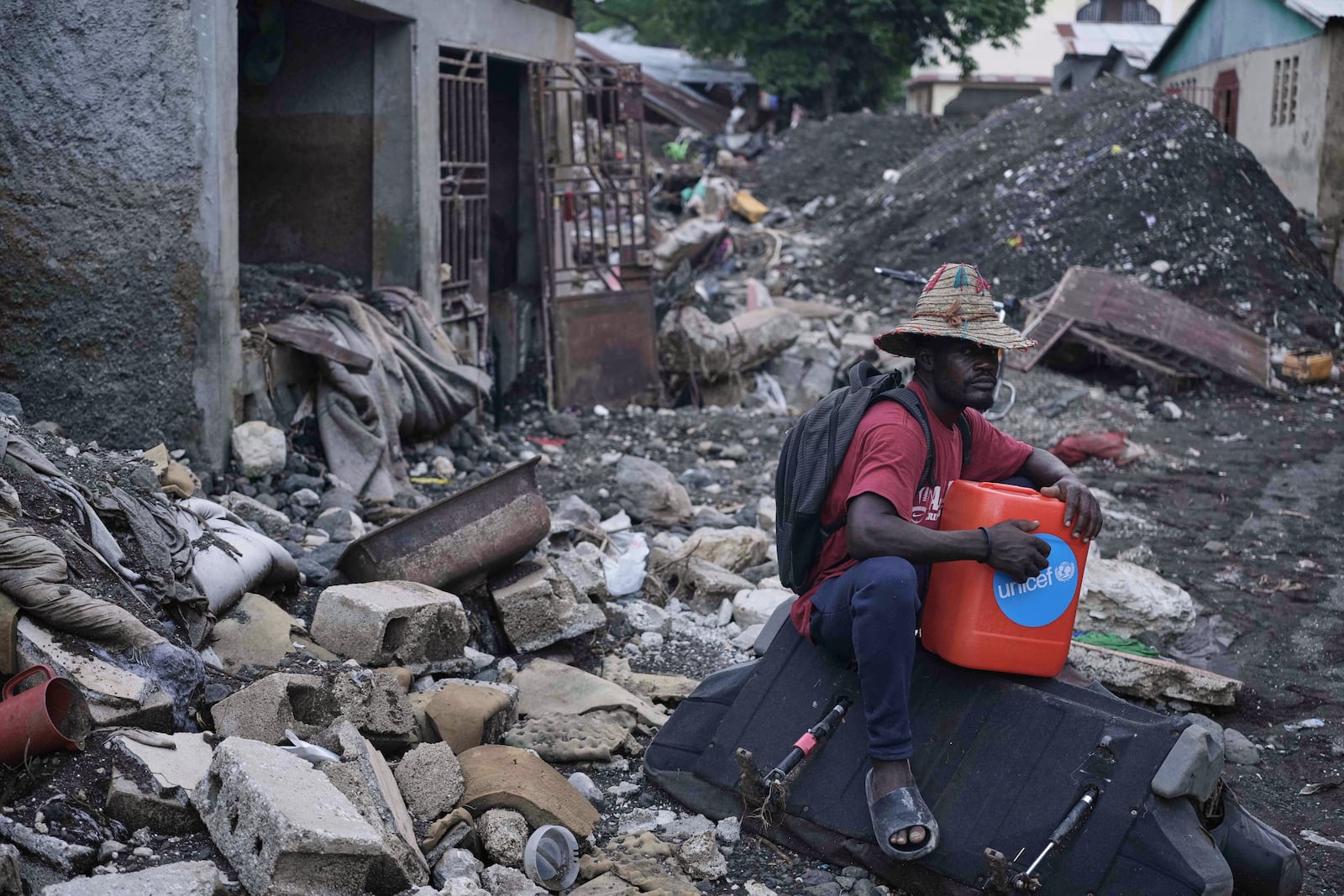 A man sits amid the debris outside his flooded-damaged home in the aftermath of Hurricane Melissa in Petit-Goave, Haiti, Thursday, Nov. 6, 2025. (AP Photo/Odelyn Joseph)