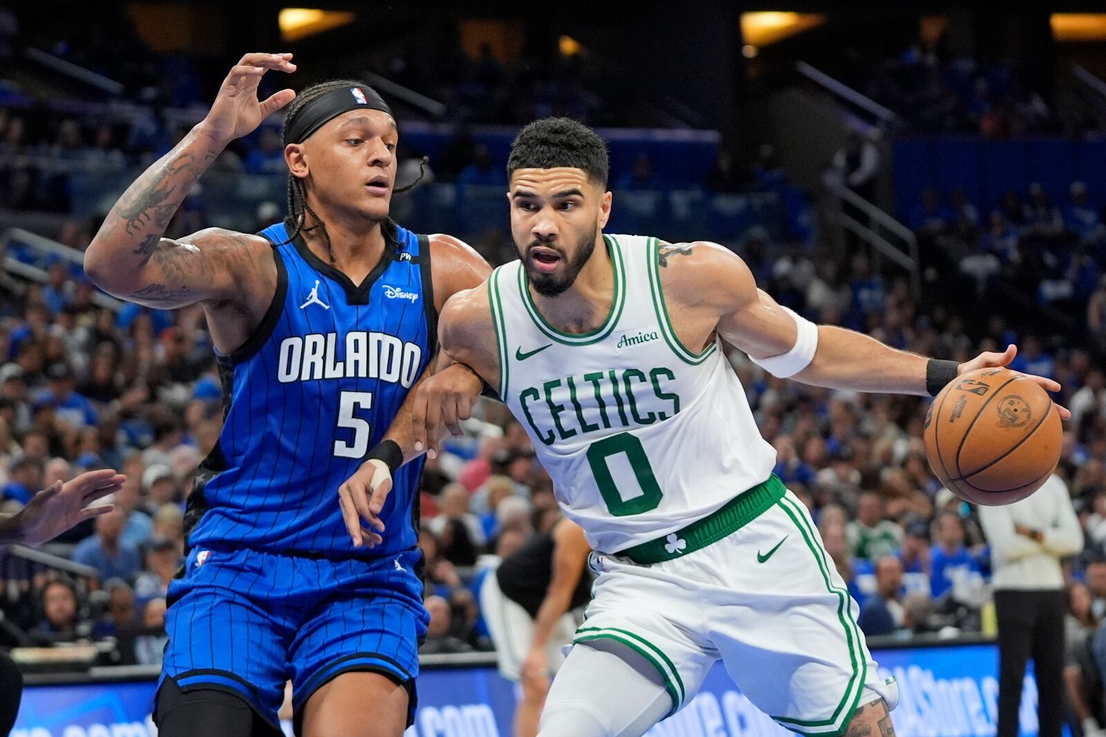 Boston Celtics forward Jayson Tatum (0) tries to get past Orlando Magic forward Paolo Banchero (5) during the first half in game 3 of a first-round NBA playoff basketball series,, Friday, April 25, 2025, in Orlando, Fla. (AP Photo/John Raoux)