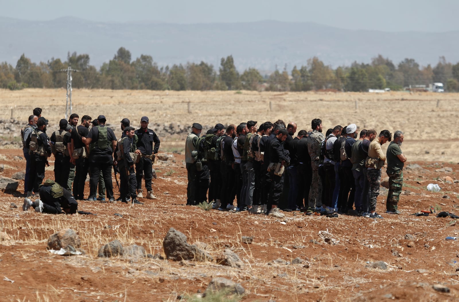 Syrian government security forces attend their noon prayer at Busra al-Harir village in Daraa, as they prepare to enter Sweida province where clashes erupted between Druze militias and Sunni Bedouin clans, southern Syria, Monday, July 14, 2025. (AP Photo/Omar Sanadiki)