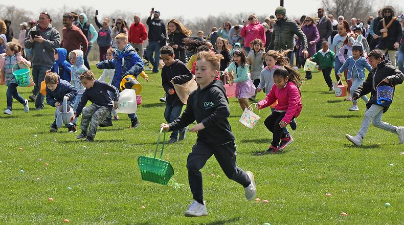 Hundreds of children race across the driving range at Young's Jersey Dairy picking up dyed hard boiled eggs during the annual Easter egg hunt Sunday. This was the 39th anniversary for the egg hunt at the dairy, however, it was the first time in two years it was held due to the COVID pandemic. This year Young's put out over 10,000 eggs for the children to collect. BILL LACKEY/STAFF