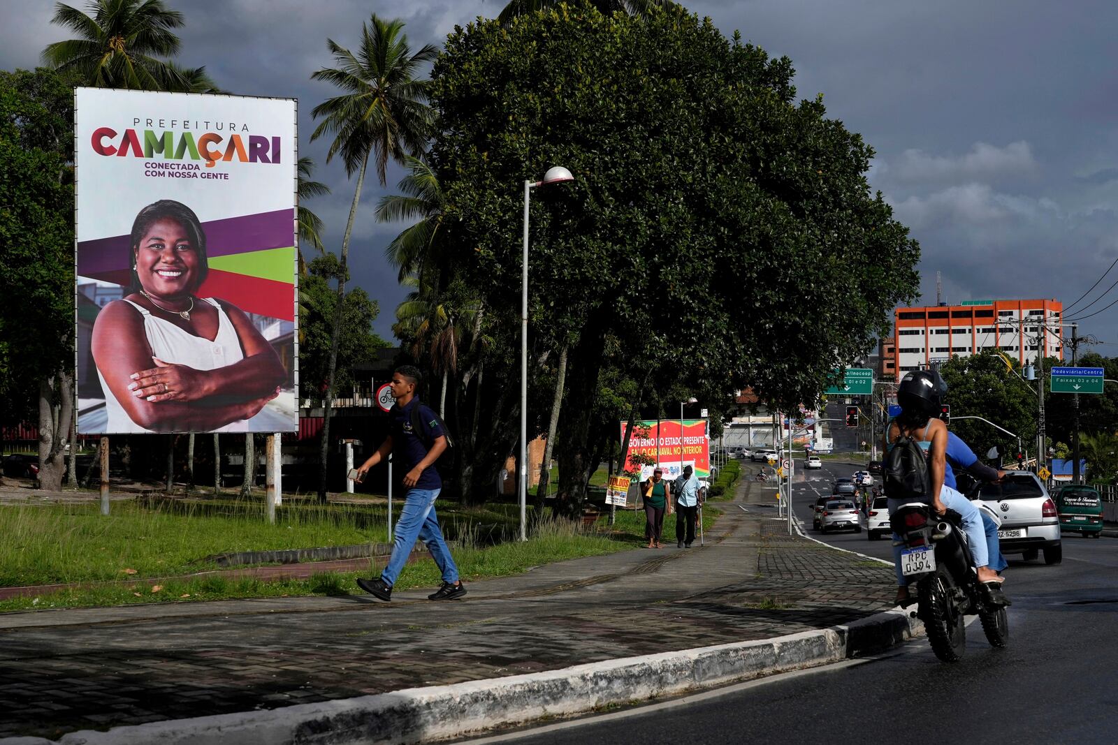 A person walks near a sign for Camacari, Bahia state, Brazil, Friday, March 7, 2025. (AP Photo/Eraldo Peres)