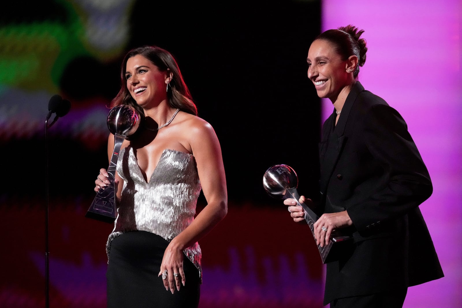 Alex Morgan, left, and Diana Taurasi react as they accept Icon Awards at the ESPY Awards at the Dolby Theatre in Los Angeles, Wednesday, July 16, 2025. (AP Photo/Mark J. Terrill)