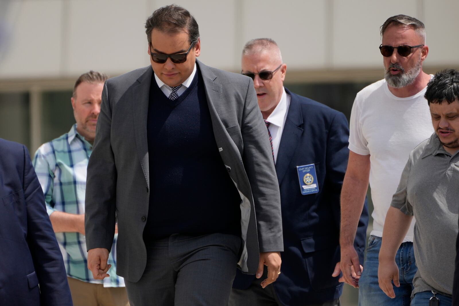 Former U.S. Rep. George Santos, left, leaves federal court after being sentenced to more than seven years in prison for fraud and identity theft, Friday, April 25, 2025, in Central Islip, N.Y. (AP Photo/Julia Demaree Nikhinson)