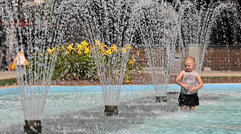 Penelope Evans cools off from the afternoon sun by wading recently in the City Hall Plaza fountain in downtown Springfield. Today will be hot and humid, which combined will make the temperature feel like it is 100 degrees or higher. BILL LACKEY/STAFF