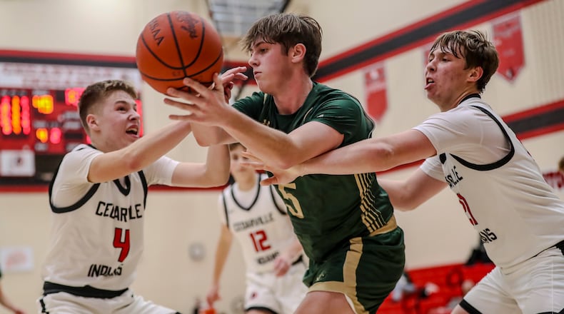 Catholic Central High School senior Zac Thompson is guarded by Cedarville's Will Mossing (left) and Nate Terrell during their game on Friday night at Cedarville High School. The Irish won 52-49. CONTRIBUTED PHOTO BY MICHAEL COOPER