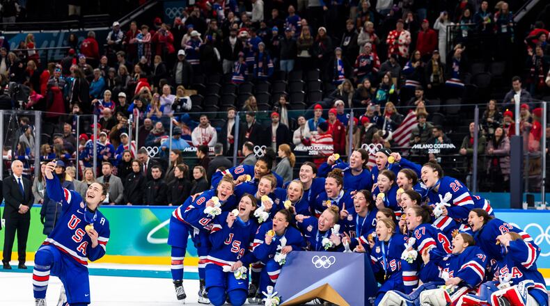 United States' Megan Keller, left, who scored the game winning goal in overtime, takes a selfie with teammates as they celebrate after defeating Canada in the women's ice hockey gold medal game at the 2026 Winter Olympics in Milan, Italy, Thursday, Feb. 19, 2026. (Salvatore Di Nolfi/Keystone via AP)