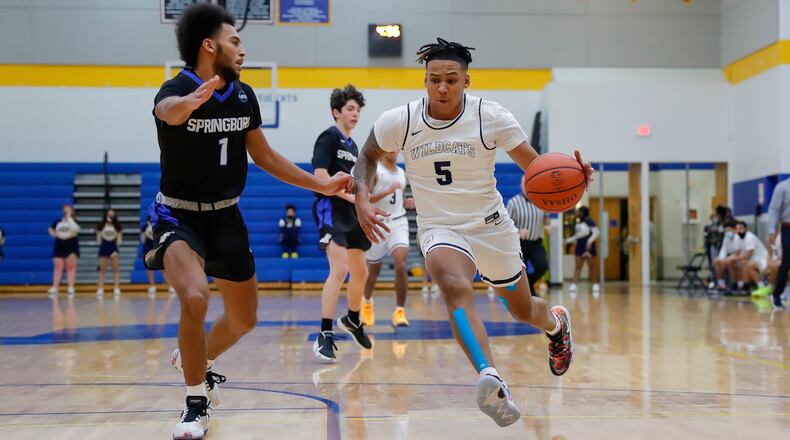 Cutline: Springfield High School senior Josh Tolliver drives past Springboro freshman Maxim Butler during their game on Dec. 18 at Springfield High School. Michael Cooper/CONTRIBUTED