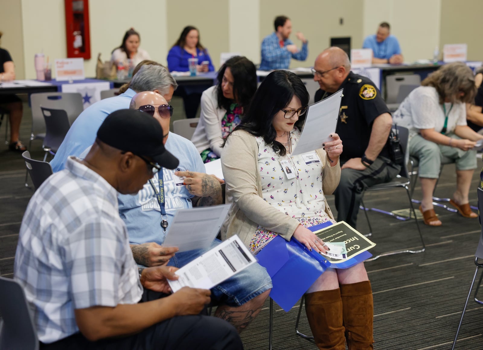 Amiee Sizemore, center, playing as "Stephanie" who's incarcerated, looks at paperwork during a reentry simulation for National Reentry Month held by the Department of Reentry on Tuesday, April 29, 2025, at the Hollenbeck Bayley Center. JOSEPH COOKE/STAFF