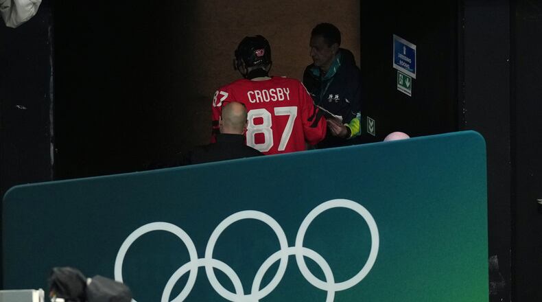 Canada's Sidney Crosby (87) is led away from the ice after being injured during the second period of a men's ice hockey quarterfinal game between Canada and Czechia at the 2026 Winter Olympics, in Milan, Italy, Wednesday, Feb. 18, 2026. (AP Photo/Hassan Ammar)