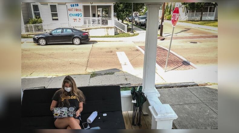Bree Nurray, a University of Dayton senior from Pittsburgh, takes an online class on the front porch of her rental house on the campus Wednesday Aug. 26, 2020.