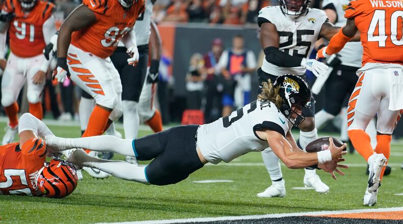 Jacksonville Jaguars quarterback Trevor Lawrence (16) dives in for touchdown while being tackled by Cincinnati Bengals' Logan Wilson (55) during the first half of an NFL football game, Thursday, Sept. 30, 2021, in Cincinnati. (AP Photo/Michael Conroy)