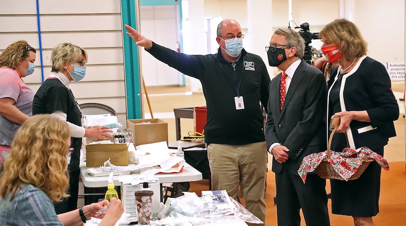Clark County Health Commissioner Charles Patterson gives Governor Mike DeWine and his wife, Fran, a tour of the Clark County COVID vaccine distribution center at the Upper Valley Mall on March 12. BILL LACKEY/STAFF